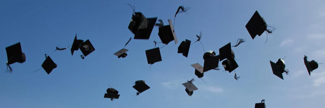 Graduation Caps in tossed in the air.