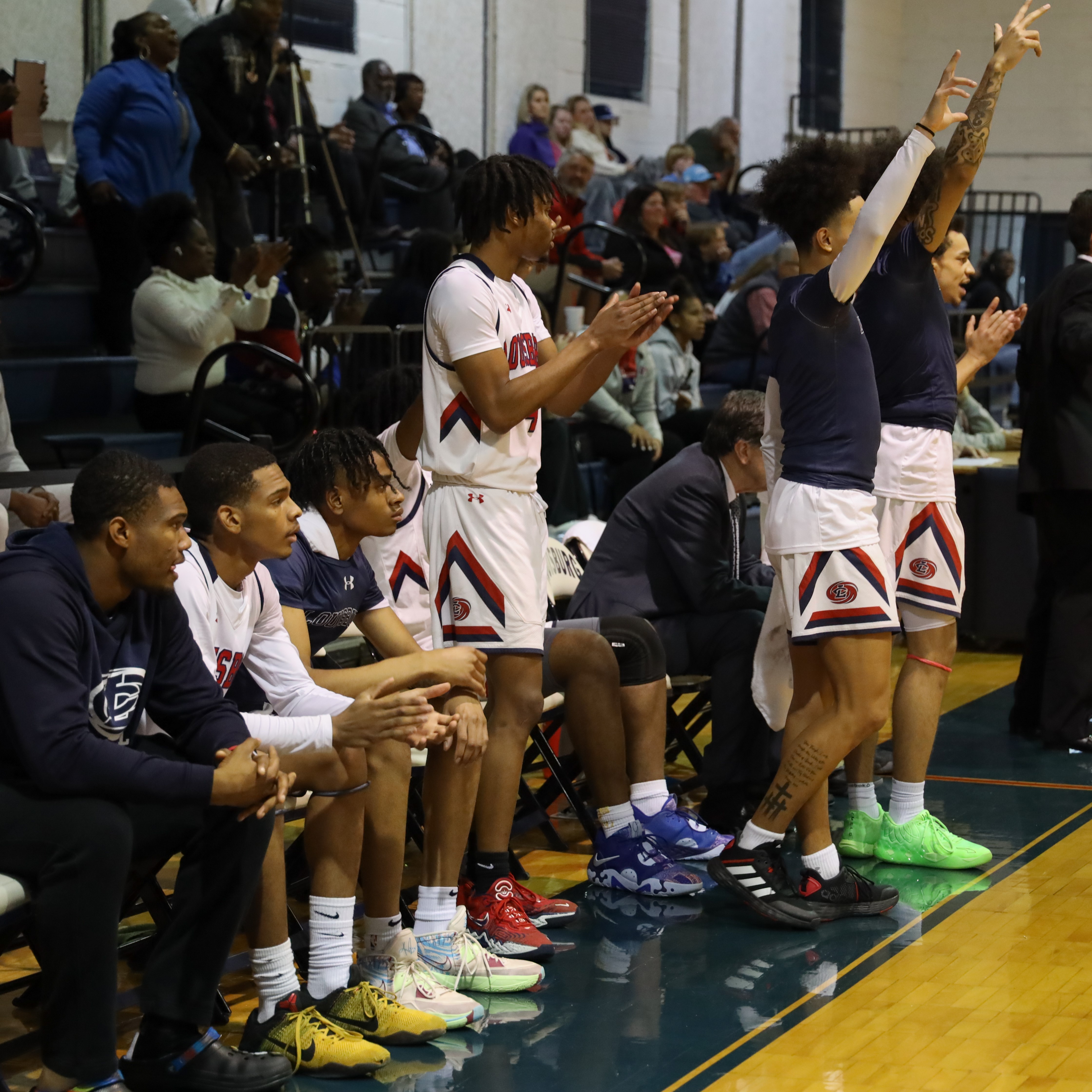 Men's basketball team celebrate a 3-point shot.