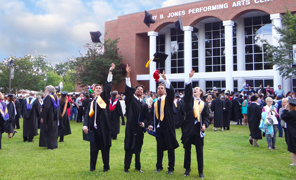 graduates throwing hats into air
