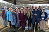 a group of people stand under a tent smiling for the camera