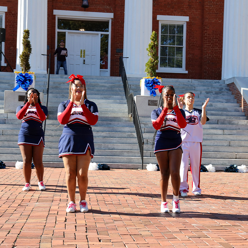 Cheerleaders performing in front of Main builiding.