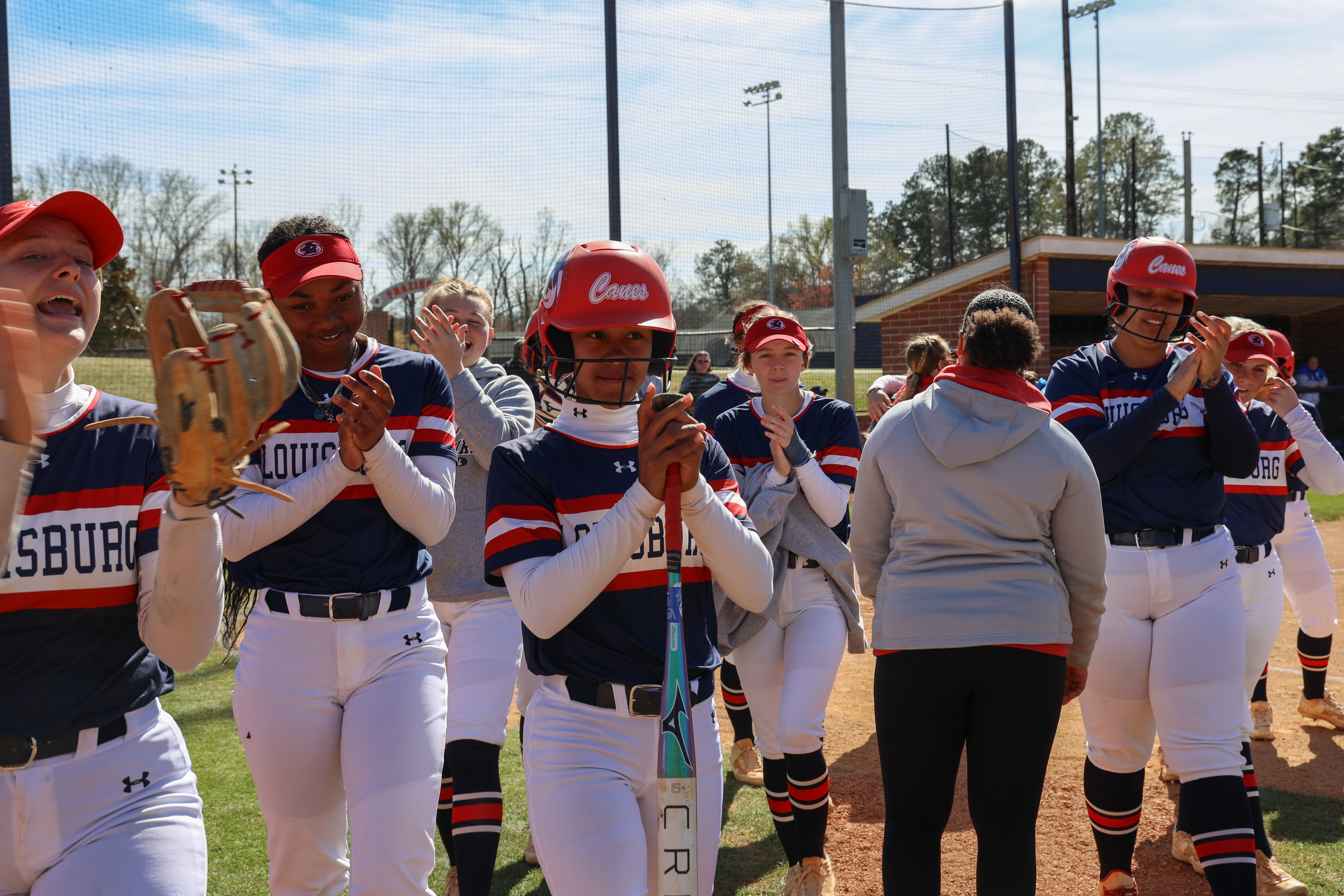 Softball team celebrates homerun.