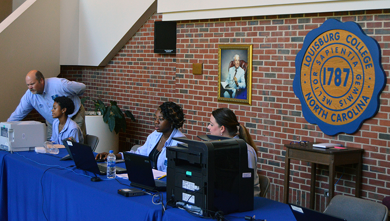 people sitting at a table with computers