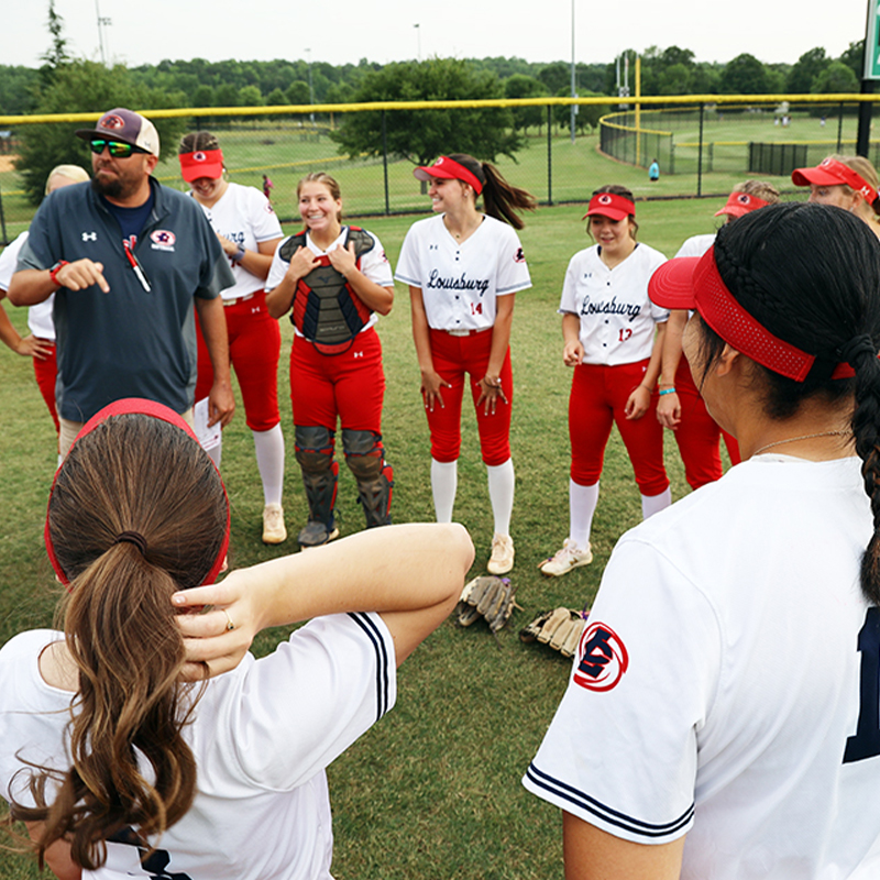 Coach Eric Lee gives softball team a pep talk before first game of NJCAA World Series tournament.